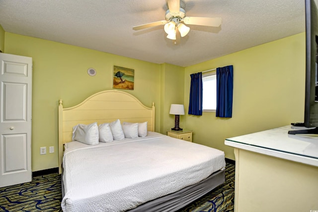 carpeted bedroom featuring a textured ceiling and ceiling fan