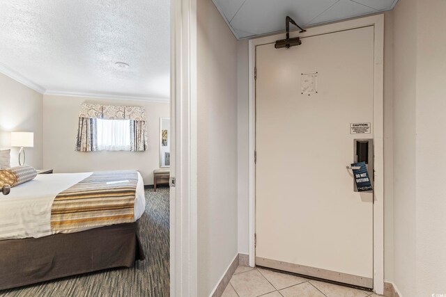 bedroom with a textured ceiling and light tile floors