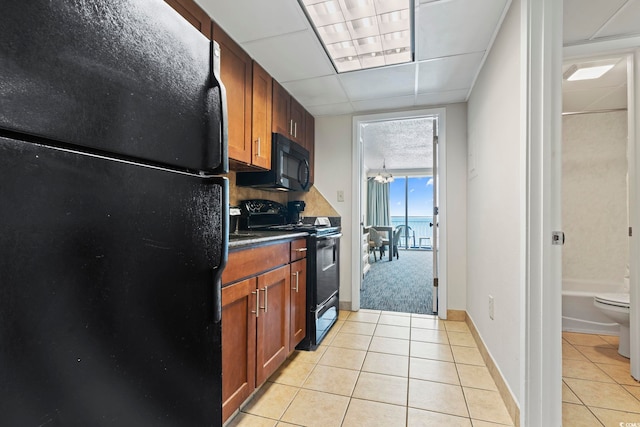 kitchen with light tile floors and black appliances