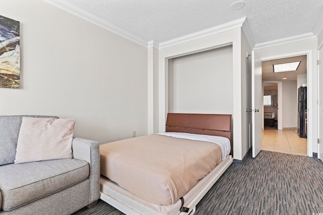 bedroom featuring dark tile flooring, a textured ceiling, and ornamental molding