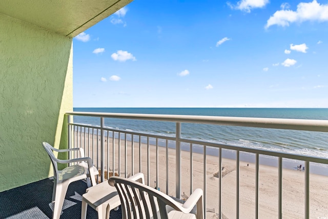 balcony featuring a beach view and a water view