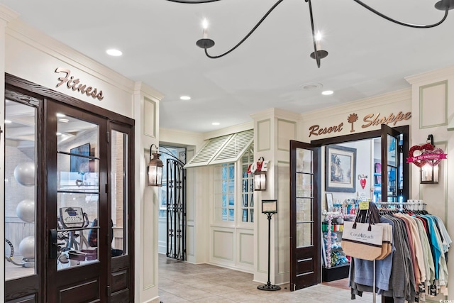 entryway with crown molding and light tile floors