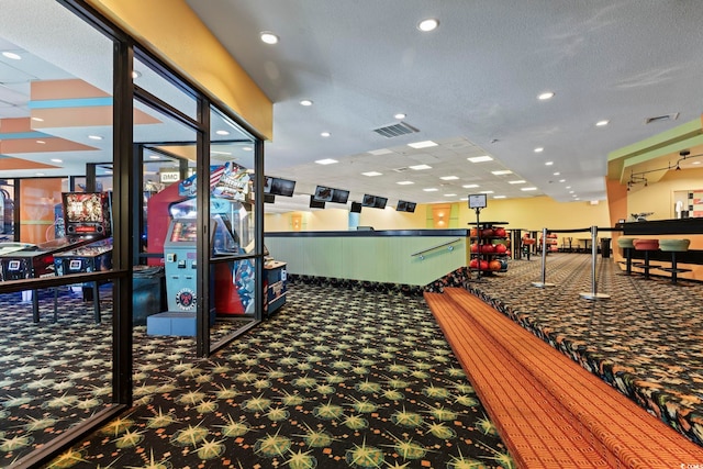 rec room featuring a textured ceiling and dark carpet