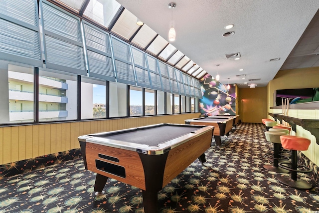 recreation room featuring a textured ceiling, dark carpet, and pool table