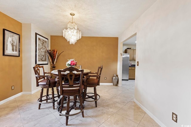 tiled dining area featuring a notable chandelier and a textured ceiling