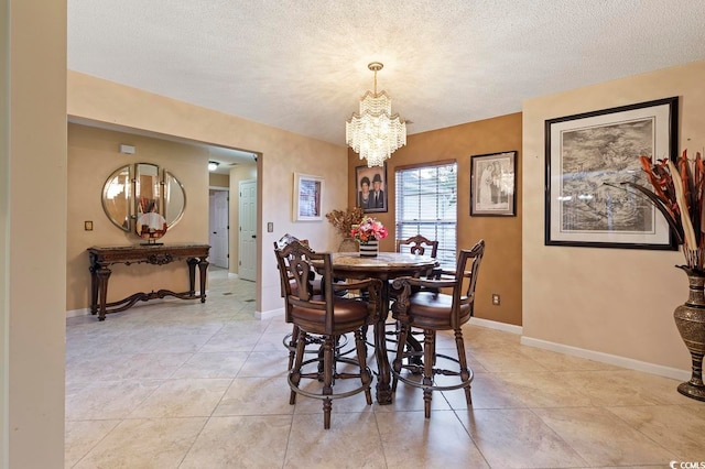 dining area with light tile flooring, a chandelier, and a textured ceiling