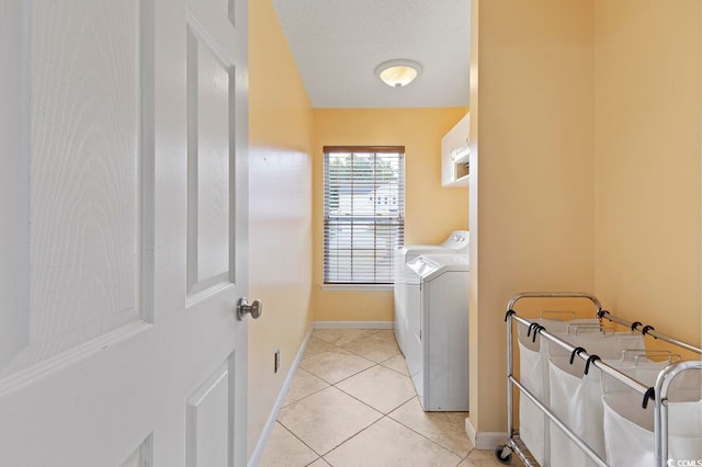 clothes washing area featuring washing machine and dryer and light tile floors