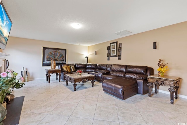 living room with a textured ceiling and light tile flooring