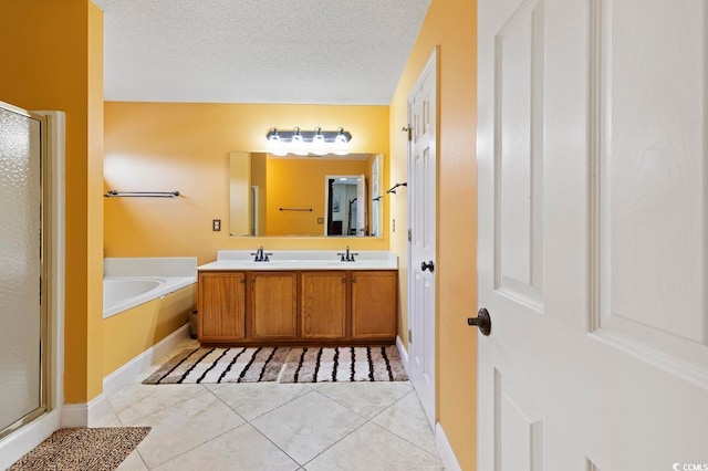 bathroom featuring a textured ceiling, tile floors, shower with separate bathtub, and double sink vanity