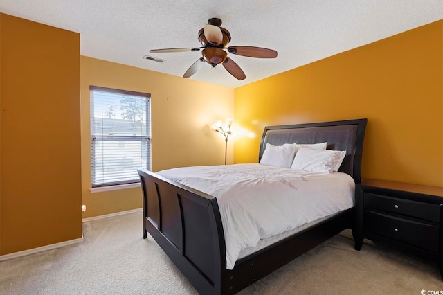 carpeted bedroom with ceiling fan and a textured ceiling