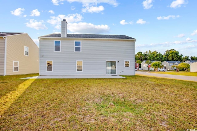 rear view of property featuring a lawn and a patio area