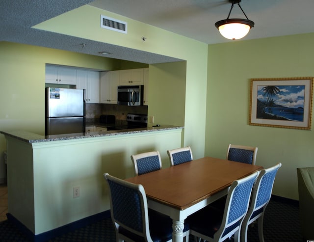 dining space featuring dark colored carpet