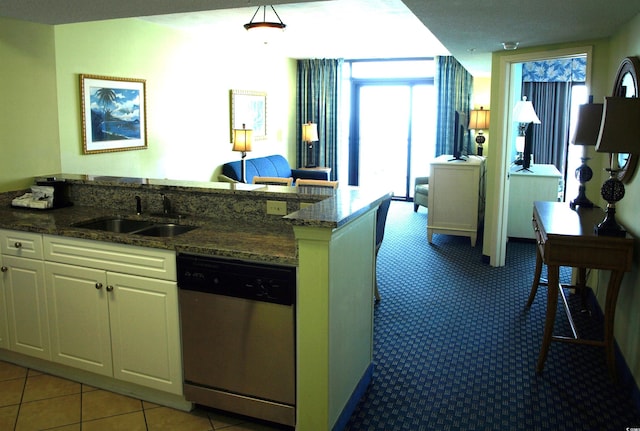 kitchen with stone counters, plenty of natural light, and stainless steel dishwasher