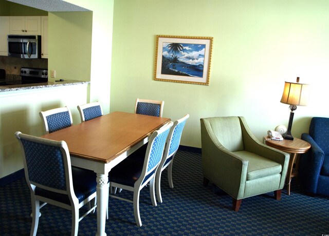 dining room featuring dark carpet