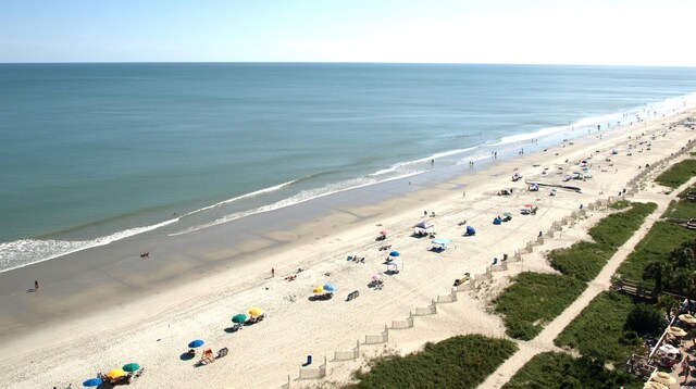 drone / aerial view featuring a water view and a view of the beach