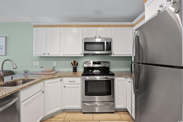 kitchen featuring white cabinetry, sink, stainless steel appliances, and light stone countertops