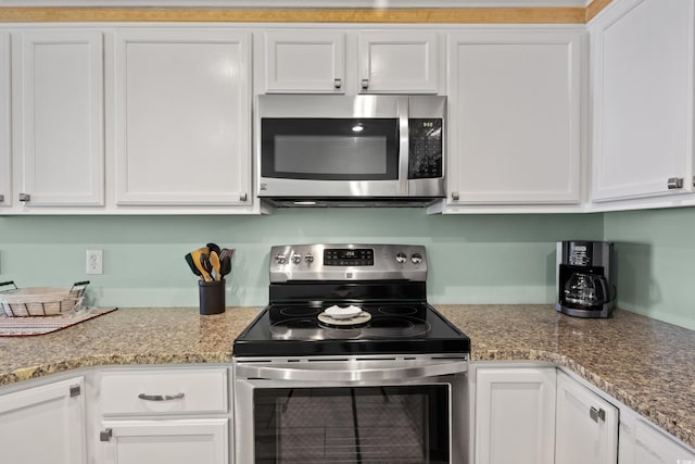 kitchen with appliances with stainless steel finishes, light stone countertops, and white cabinets