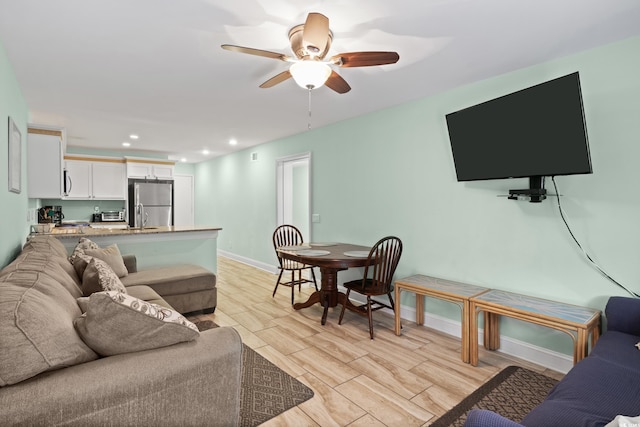 living room featuring ceiling fan and light hardwood / wood-style flooring