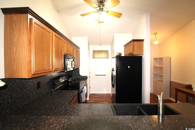 kitchen with vaulted ceiling, decorative light fixtures, sink, decorative backsplash, and black appliances