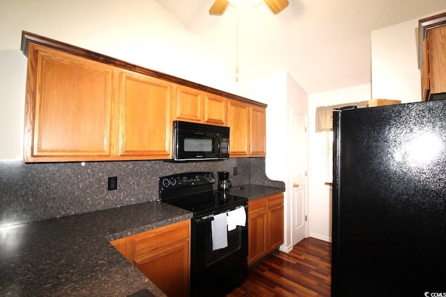 kitchen with lofted ceiling, dark stone countertops, dark hardwood / wood-style floors, black appliances, and decorative backsplash