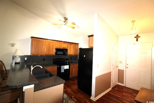 kitchen with lofted ceiling, sink, black appliances, and kitchen peninsula