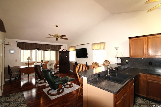 kitchen with sink, a kitchen breakfast bar, dark hardwood / wood-style floors, kitchen peninsula, and ceiling fan