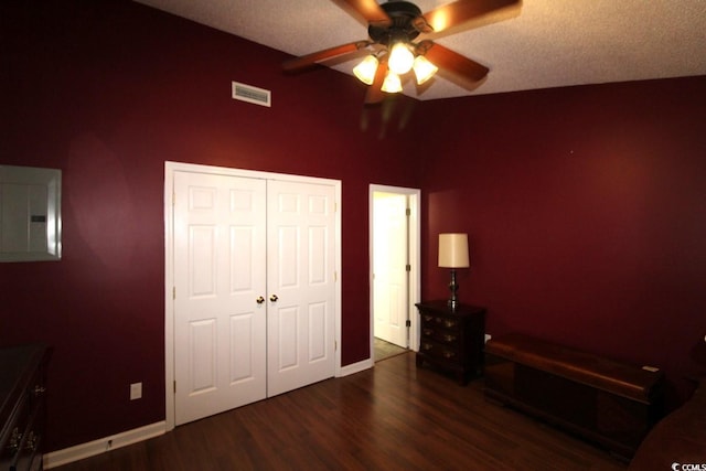 unfurnished bedroom with dark wood-type flooring, electric panel, a closet, and ceiling fan