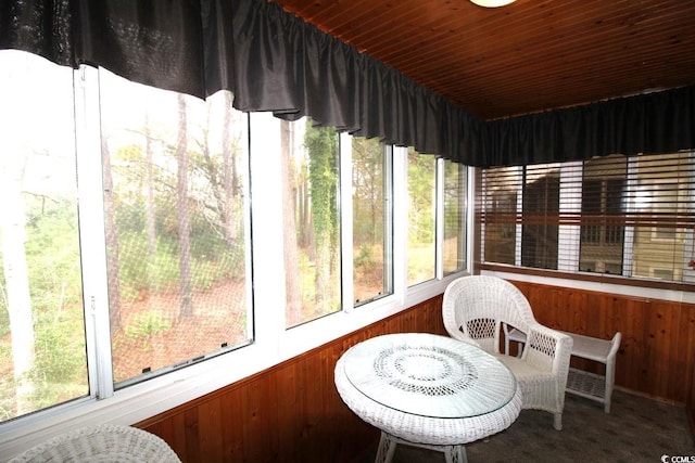 sunroom featuring wood ceiling and a healthy amount of sunlight