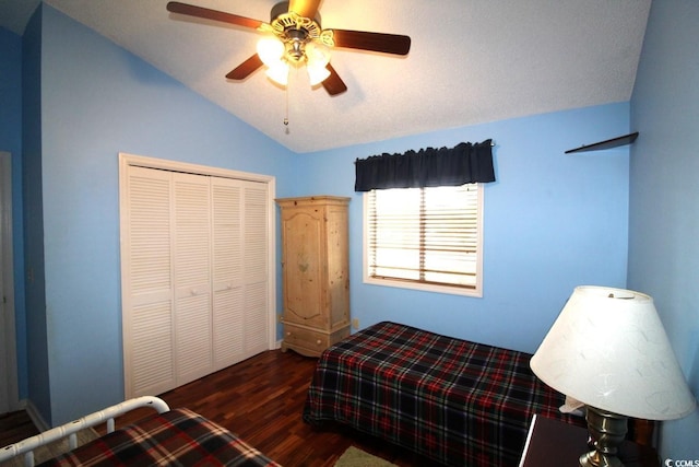 bedroom featuring dark wood-type flooring, vaulted ceiling, a closet, and ceiling fan