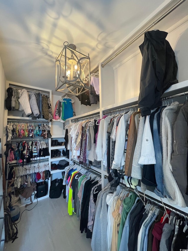 spacious closet featuring an inviting chandelier