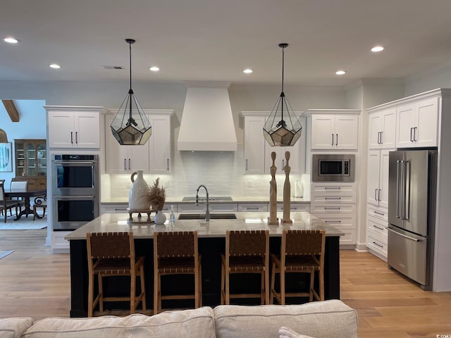 kitchen featuring pendant lighting, stainless steel appliances, white cabinetry, and custom exhaust hood