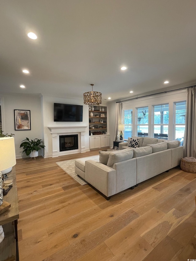 living room featuring built in features and light hardwood / wood-style floors