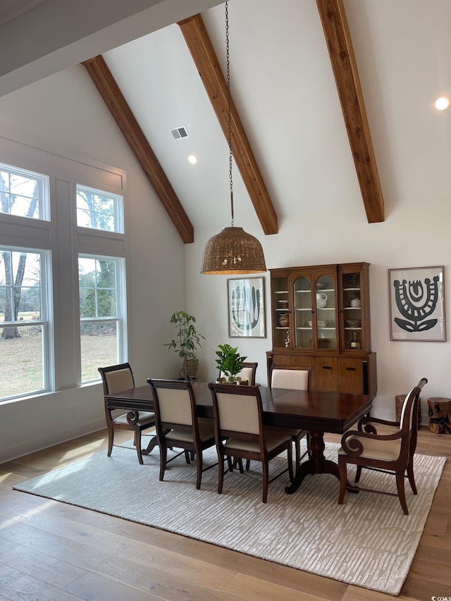 dining area with beam ceiling, wood-type flooring, and high vaulted ceiling