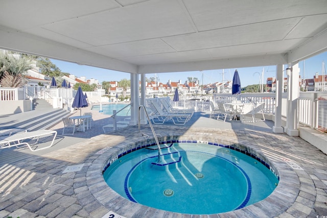 view of swimming pool featuring a community hot tub and a patio area