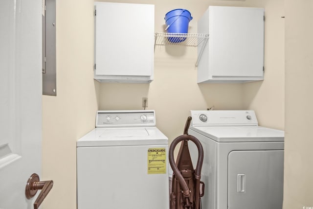 clothes washing area featuring cabinets and washer and clothes dryer