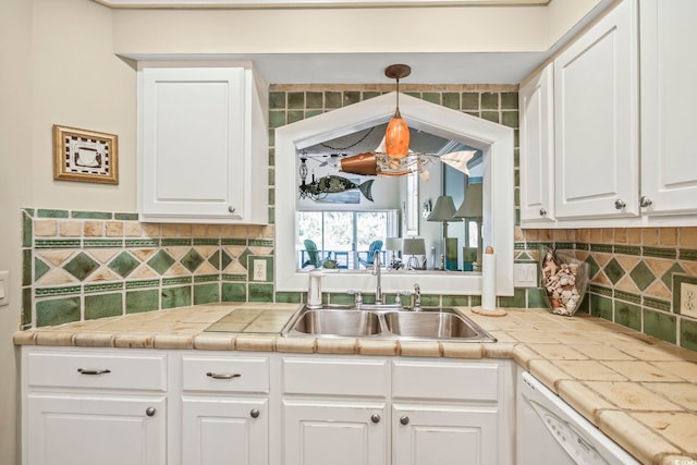 kitchen featuring white cabinetry, tile countertops, sink, and tasteful backsplash