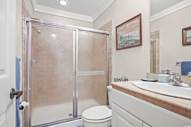 bathroom featuring a textured ceiling, ornamental molding, toilet, and vanity with extensive cabinet space