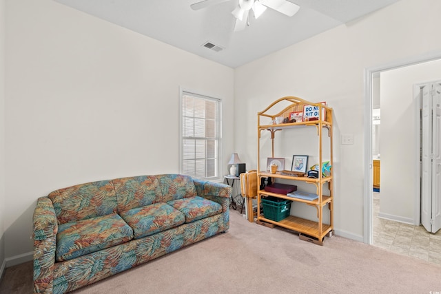 living area featuring light colored carpet and ceiling fan