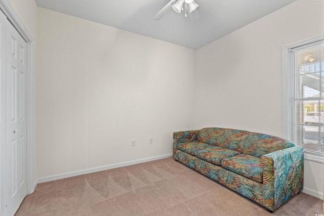 living area featuring ceiling fan and light carpet