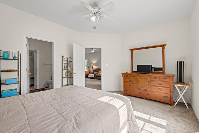 bedroom with ceiling fan, light colored carpet, and ensuite bathroom