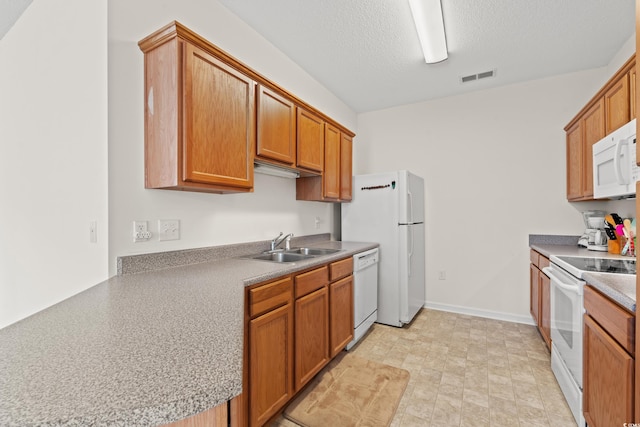 kitchen featuring a textured ceiling, white appliances, light tile flooring, and sink