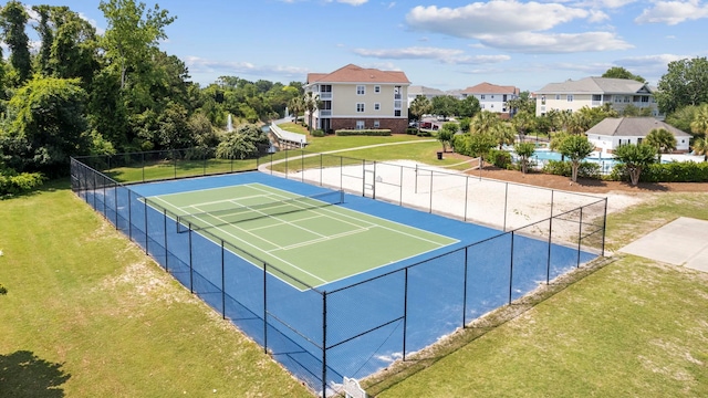 view of tennis court featuring a yard