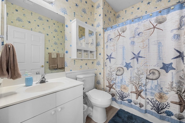 bathroom with wood-type flooring, toilet, and vanity with extensive cabinet space