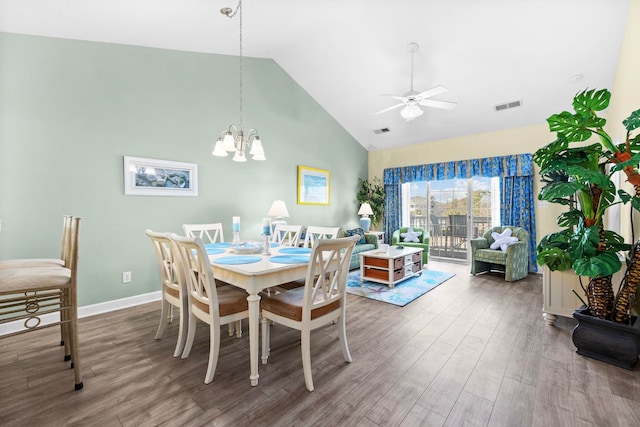 dining area featuring high vaulted ceiling, hardwood / wood-style flooring, and ceiling fan with notable chandelier