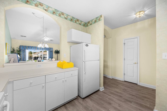 kitchen featuring white cabinets, wood-type flooring, ceiling fan, and white refrigerator