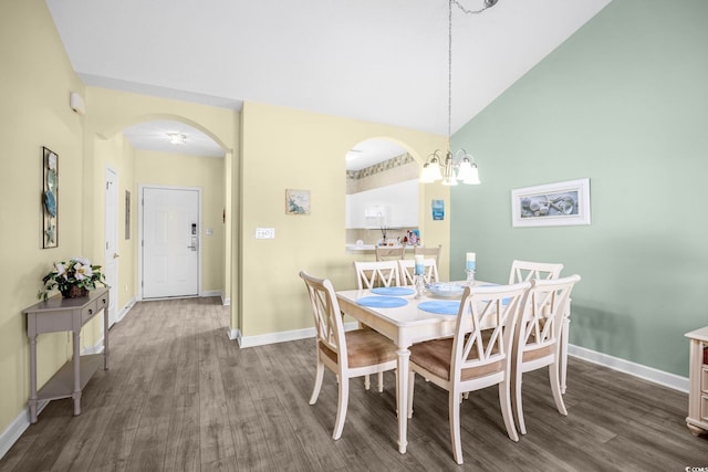 dining room with high vaulted ceiling, an inviting chandelier, and dark hardwood / wood-style flooring