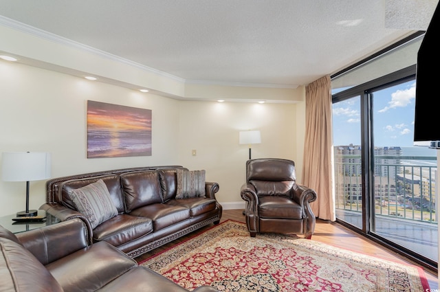 living room featuring a textured ceiling, crown molding, light hardwood / wood-style floors, and a wall of windows