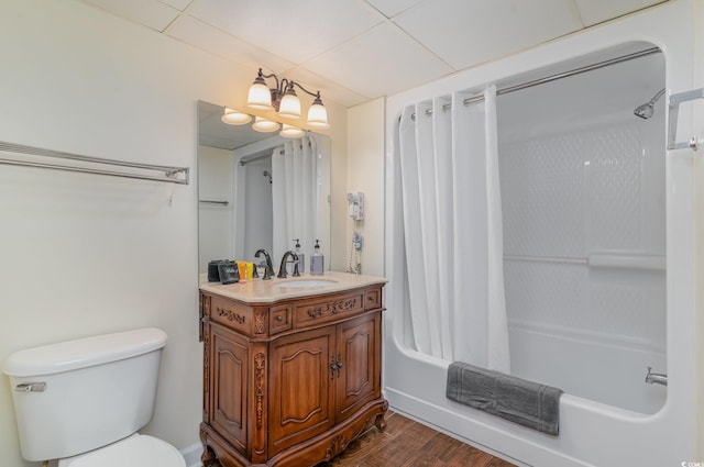 full bathroom with toilet, a paneled ceiling, wood-type flooring, oversized vanity, and shower / bathtub combination with curtain