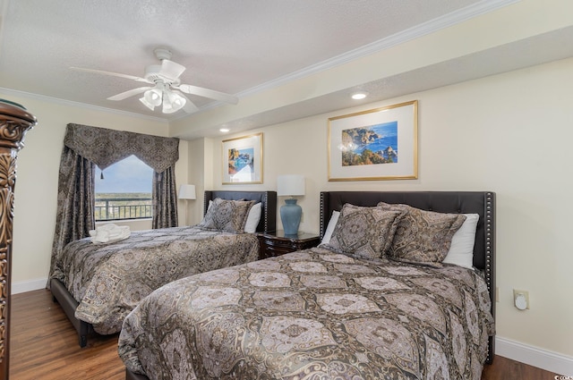 bedroom featuring ceiling fan, a textured ceiling, ornamental molding, and dark hardwood / wood-style floors