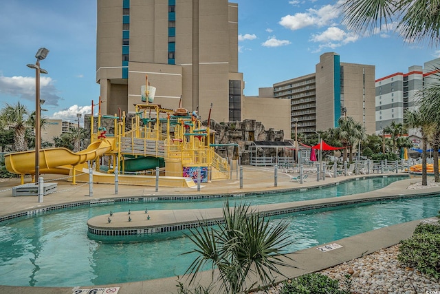 view of swimming pool with a water slide and a playground